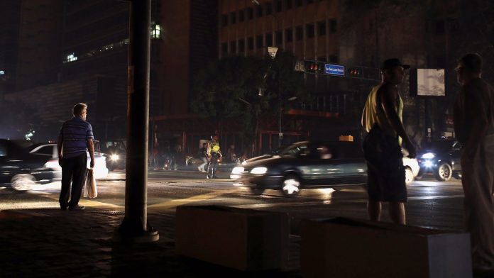 Police officers assist with traffic control along a road during a blackout in Caracas
